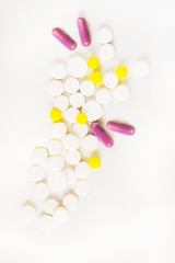 medicines various tablets and capsules  on a white  background with  container in blur on behind