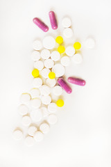 medicines various tablets and capsules on a white background with container in blur on behind