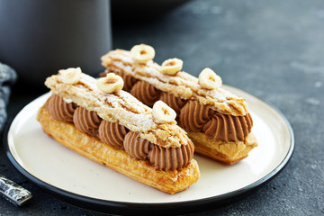 Homemade eclair with chocolate and nuts. Pastry.