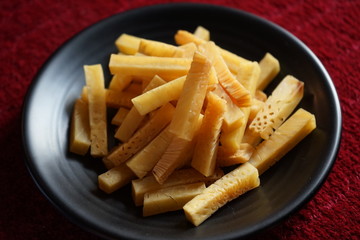 Crunchy fried of Breadfruits set on the black bowl, photographed on the red background.
