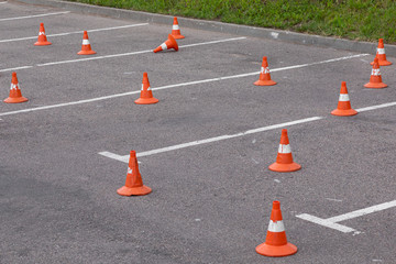Parking spots with road marking and orange safety cones standing