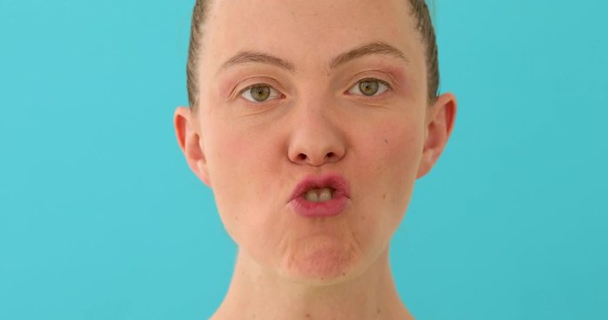 Woman's face warming up voice and vocal cords before performance on blue background