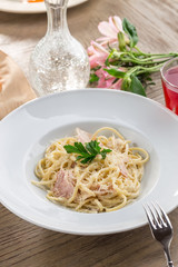 Spaghetti Carbonara with bacon and cheese and red drink on wooden table