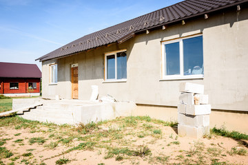 Country houses under construction on green field.