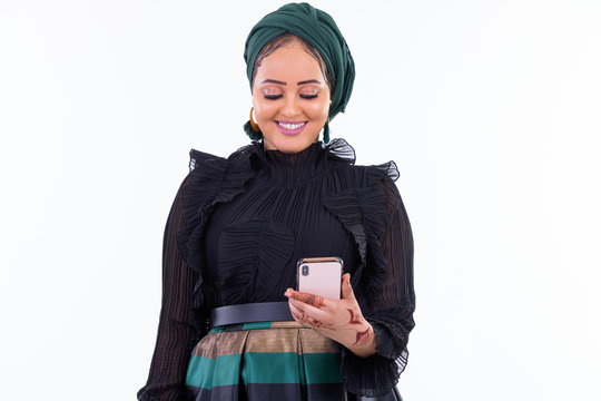 Happy young beautiful African Muslim woman using phone