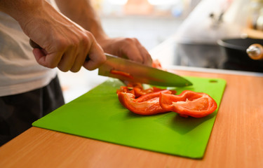 Man slicing vegetable  red peppers