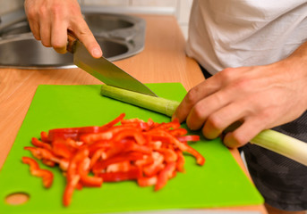 Man slicing vegetable  red peppers