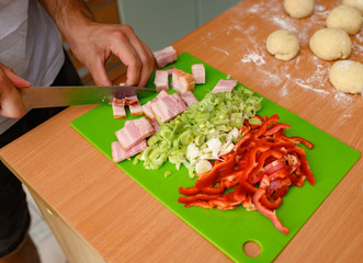 Man slicing ham together with vegetables