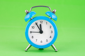 Classic alarm clock on a green background