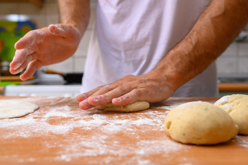man preparing dough with flour