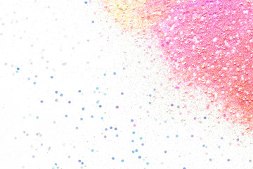 Many multi-colored spangles are scattered on a white background.