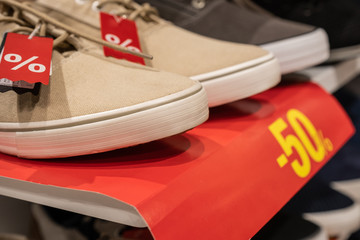 rack with  discounted shoe in a store. 50% sale on footwear in the supermarket