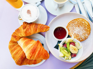 Breakfast with orange juice and fresh fruits on table