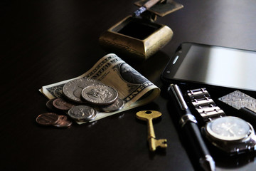 Still life of male cool belongings with dollar bills and coins