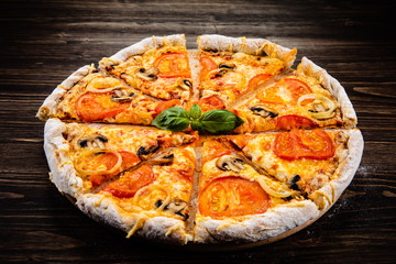 Pizza with tomatoes and champignon on cutting board