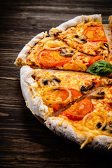 Pizza with tomatoes and champignon on cutting board