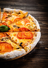 Pizza with tomatoes and champignon on cutting board