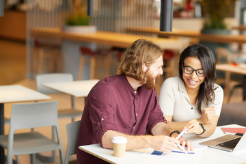 Young business people have a meeting in cafe they sitting at the table and discussing new business project in team