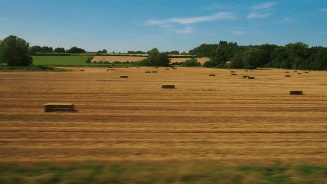 Passenger view of amazing croplands and rolling hills in the Cotswolds in England, UK, an Area of Outstanding Natural Beauty with 787 square miles, the second largest protected landscape in England