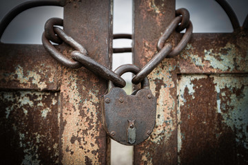 Close up of old metal lock and chain on the ground.