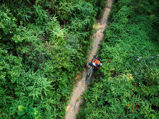 Cross country biking woman cyclist set the smartwatch on tropical forest trail
