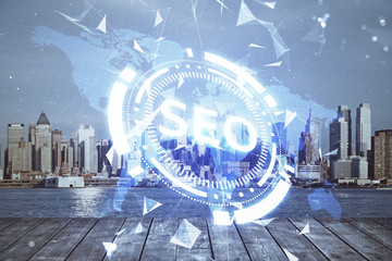SEO hologram on city view with skyscrapers background double exposure. Search optimization concept.