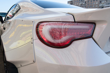 White sports car closeup. Problems with rear lights. Fogged up backlight. Condensation in taillights. Repairs needed.