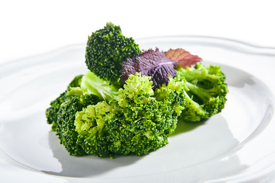 Macro Shot of Steamed Broccoli on White Restaurant Plate Isolated