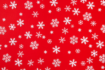 Creative arrangement of christmas decoration snowflakes on red background. Holiday concept. Flat lay, top view.