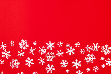 Creative arrangement of christmas decoration snowflakes on red background. Holiday concept. Flat lay, top view.