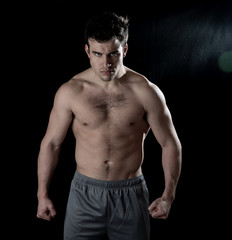 Fototapeta premium Young fitness muscly man showing his back,shoulders, triceps and biceps muscles after training