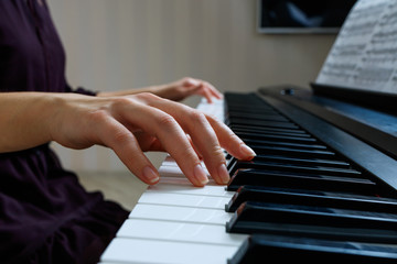 Fototapeta premium Young woman playing piano
