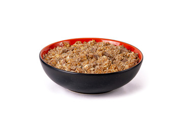 Sprouted wheat porridge with beef meat in red and black bowl. Isolated on white background. Idea for healthy diet meal.