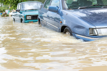 Cars driving on a flooded road, The broken car is parked in a flooded road. .