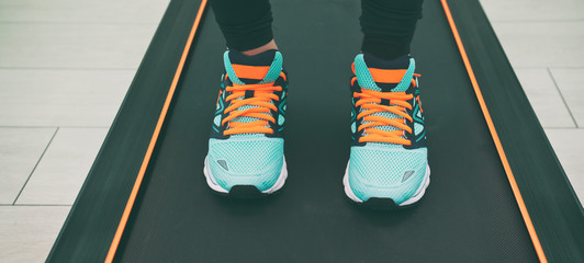 The woman's legs in new sneakers on the treadmill