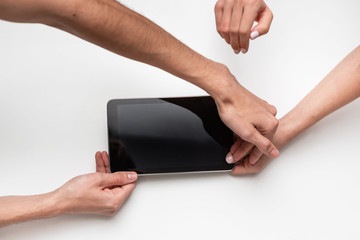 Top view of male and female hands holding tablet. Breaching of contract.