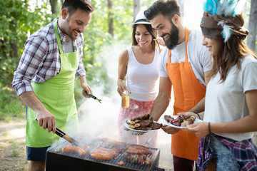 Happy friends camping and having a barbecue in nature