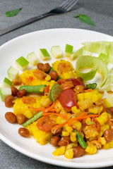 Fruit spicy salad in white dish on concrete table.