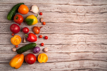 A set of vegetables. Fresh cucumbers, red and orange tomatoes, onions, garlic, red, orange and yellow bell peppers, cherry tomatoes. Ingredients for a vegetable salad.