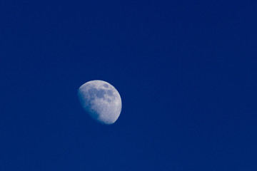 La luna a tre quarti sul cielo notturno blu