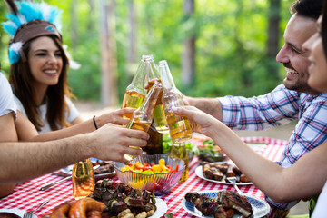 Group of happy friends having a barbecue party in nature