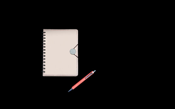 Recycled closed notebook with elastic band and orange pend on black background.