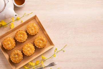 Mid-Autumn Festival holiday concept design of moon cake, mooncakes, tea set on bright wooden table with copy space, top view, flat lay, overhead shot