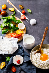 Baking background.Ingredients summer cake with cherry tomatoes, basil and brie cheese.