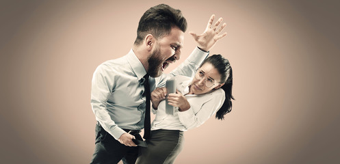 Fototapeta na wymiar Angry businessman screaming at employee in the office. Caucasian woman is under the pressure and agressia from her boss. Office work and problem, corporate, business concept.