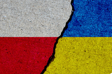 poland and ukraine flags painted over cracked concrete wall