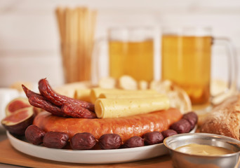 Sausage and cheese slices with light beer, pistachios, mustard and ciabatta bread for Oktoberfest