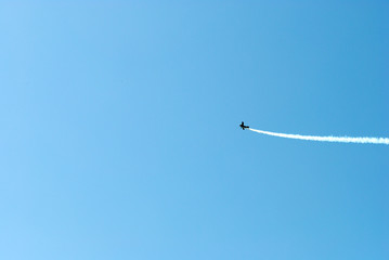 The plane leaves a trail in the sky.