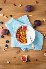 Granola  withfigs and yogurt on wooden table