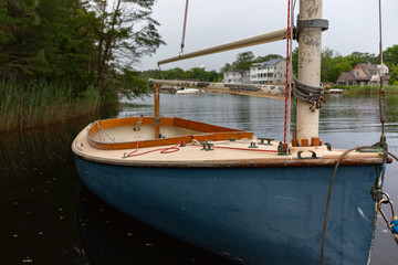 Small sailboat floating on a populated waterway